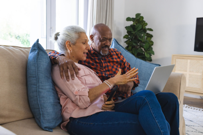Elderly_Couple_Using_A_Laptop_At_Home_Living_Room_original_3606913